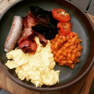 Full-house Breakfast with pork banger, free-range eggs, slow-roasted tomato, Neil Jewel''s home-cured bacon and baked beans
