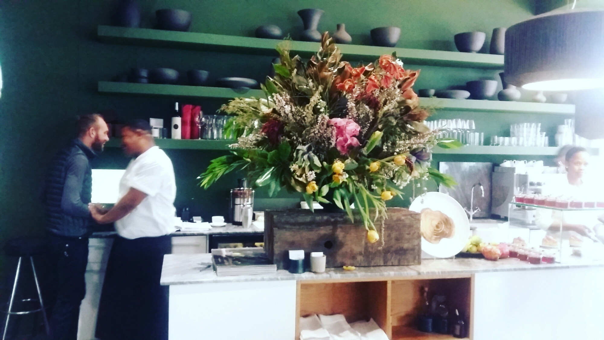 Exuberant floral display, tarts, fruit preserves and jellies on the service counter